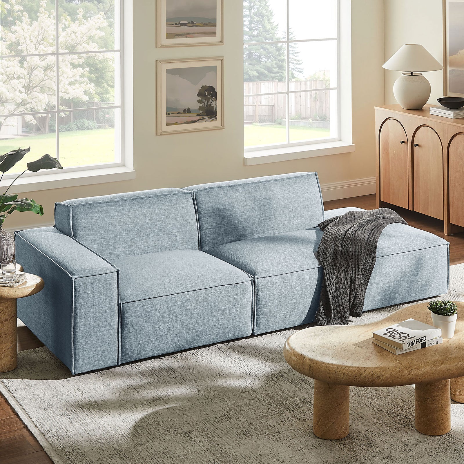 Sky blue modular loveseat anchors a bright living room with inviting chaise lounge and tailored cushions || EEI-7425-SKY || front_angle_room
