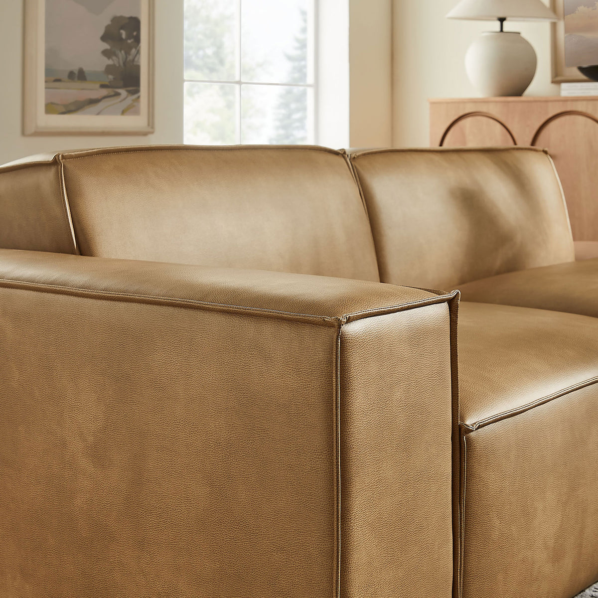 Wide arm and back cushions showing the soft vegan leather and refined piping. || EEI-7426-TST || detail_room