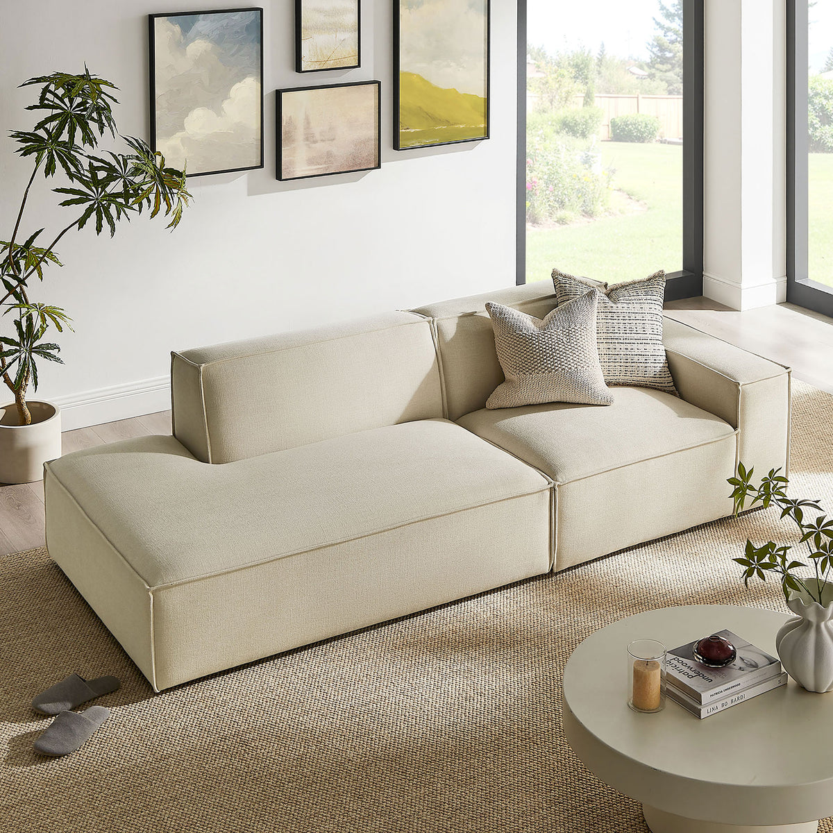 Ecru modular loveseat arranged in a sunlit living room with textured rug, plants, and modern decor || EEI-7427-ECR || front_angle_room