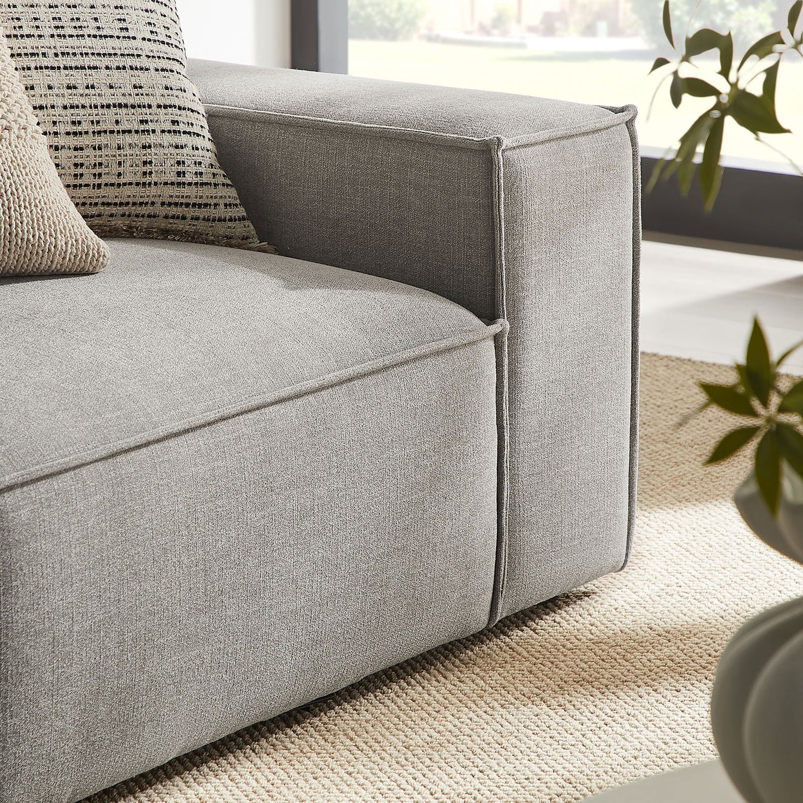 Detail of loveseat arm with contrast pillows and crisp piping on the pewter performance fabric. || EEI-7427-PEW || detail_room