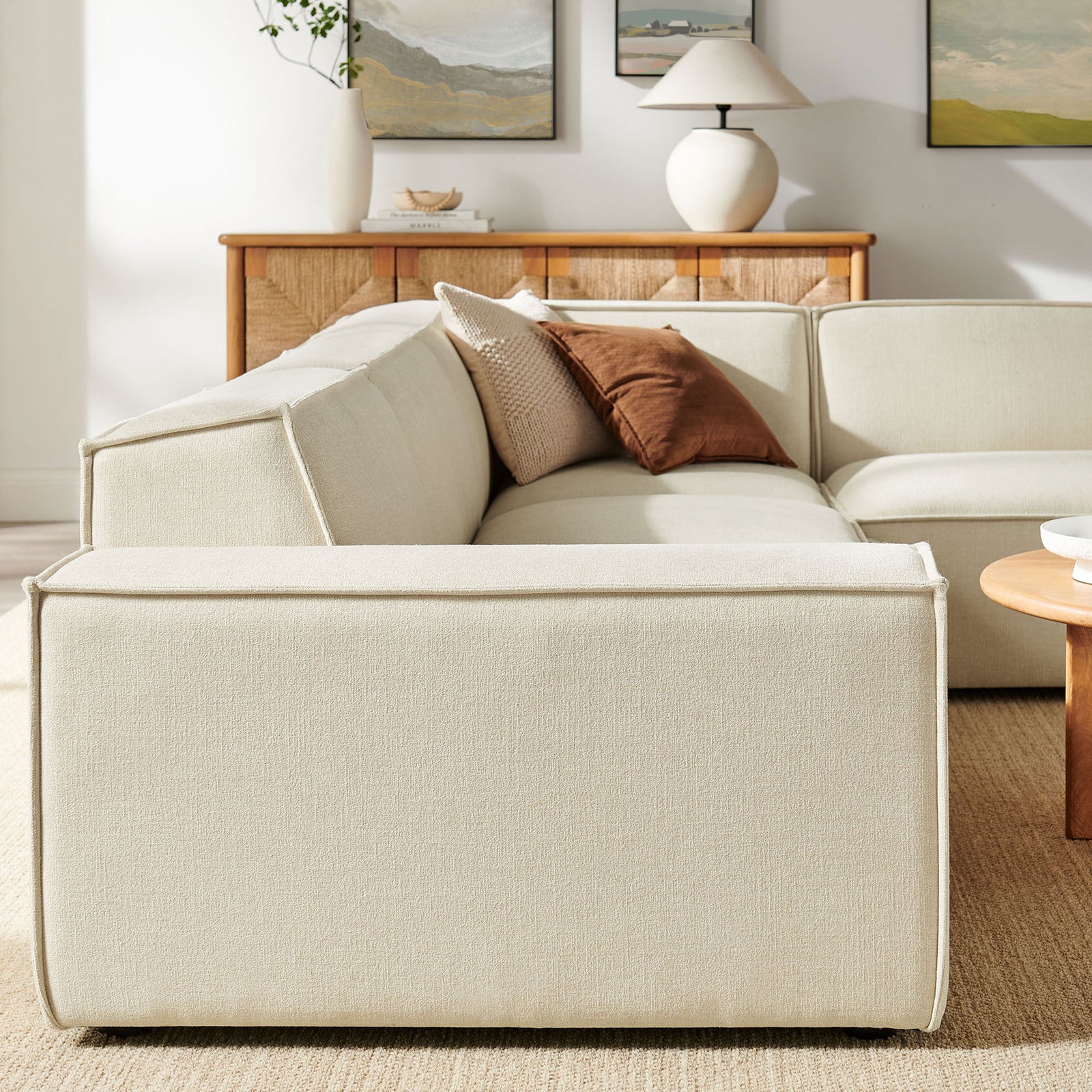 Low-profile back and tailored seams of the Restore sectional styled in a warm, neutral living room || EEI-7429-ECR || detail_room