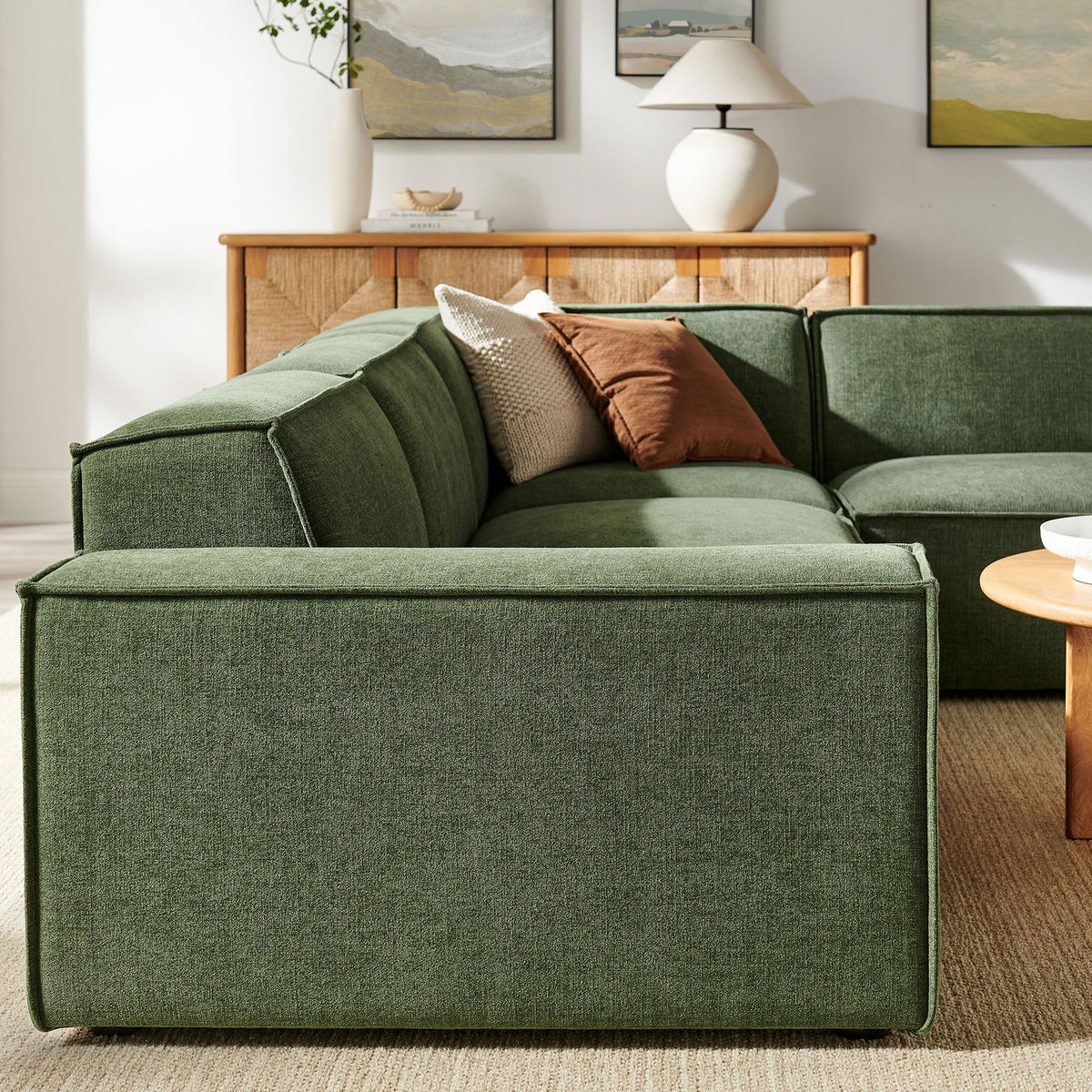 Restore foliage green modular sectional back cushions and clean seams paired with warm wood credenza and artful decor || EEI-7429-FOL || detail_room