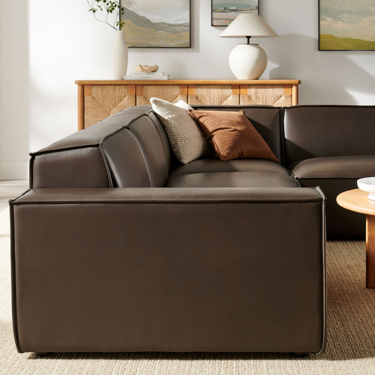 Restore espresso vegan leather sectional highlighting its smooth low-profile back, tailored seams, and clean modern silhouette in a cozy living room || EEI-7430-ESP || back_angle_room