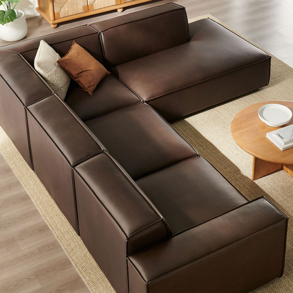 Modular espresso vegan leather sectional with right chaise and generous lounging space, integrating seamlessly into a warm contemporary living area || EEI-7430-ESP || top_angle_room