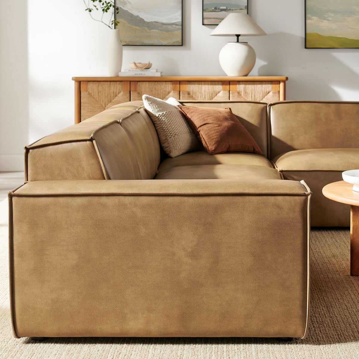 Smooth vegan leather back cushions and tailored piping detailing the clean silhouette of the sectional || EEI-7430-TST || detail_room