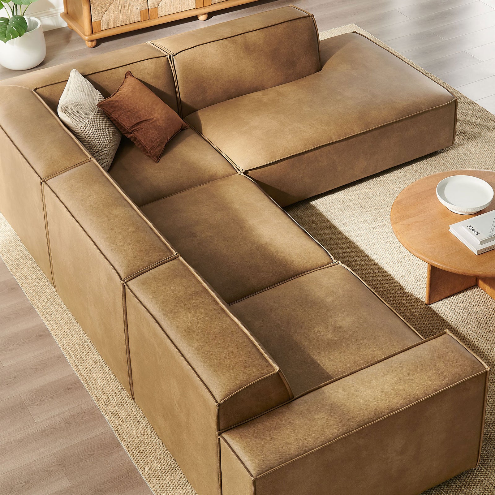 Right-chaise modular sectional arranged with a round wood coffee table on a textured area rug || EEI-7430-TST || top_angle_room