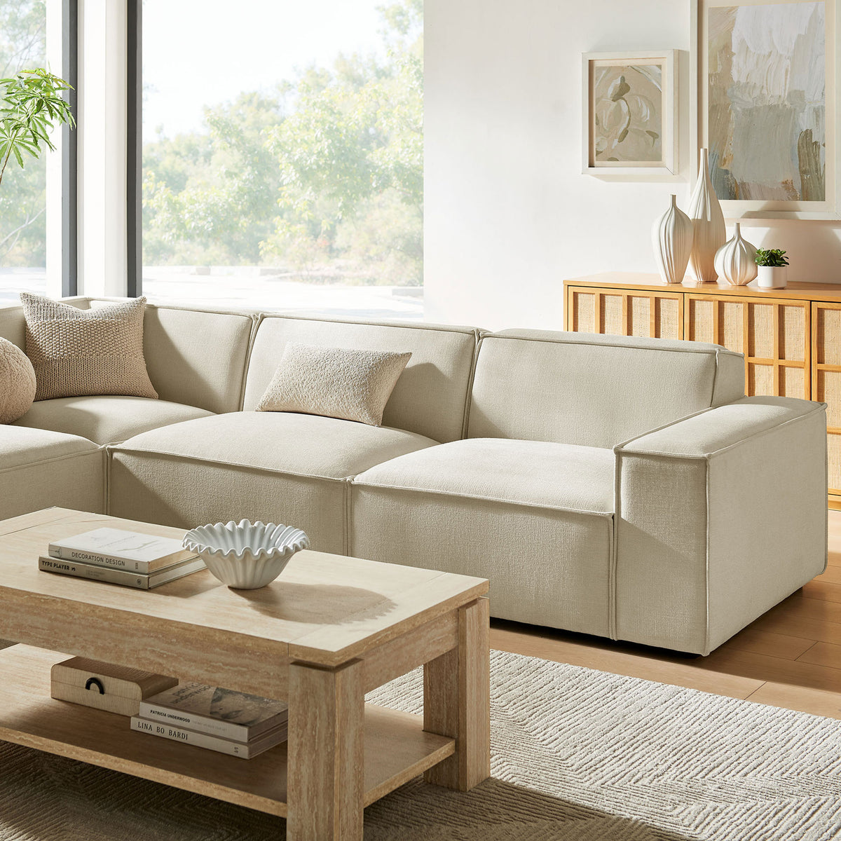 Cozy corner of the Restore sectional styled with neutral pillows in a bright, sunlit living room || EEI-7431-ECR || detail_room