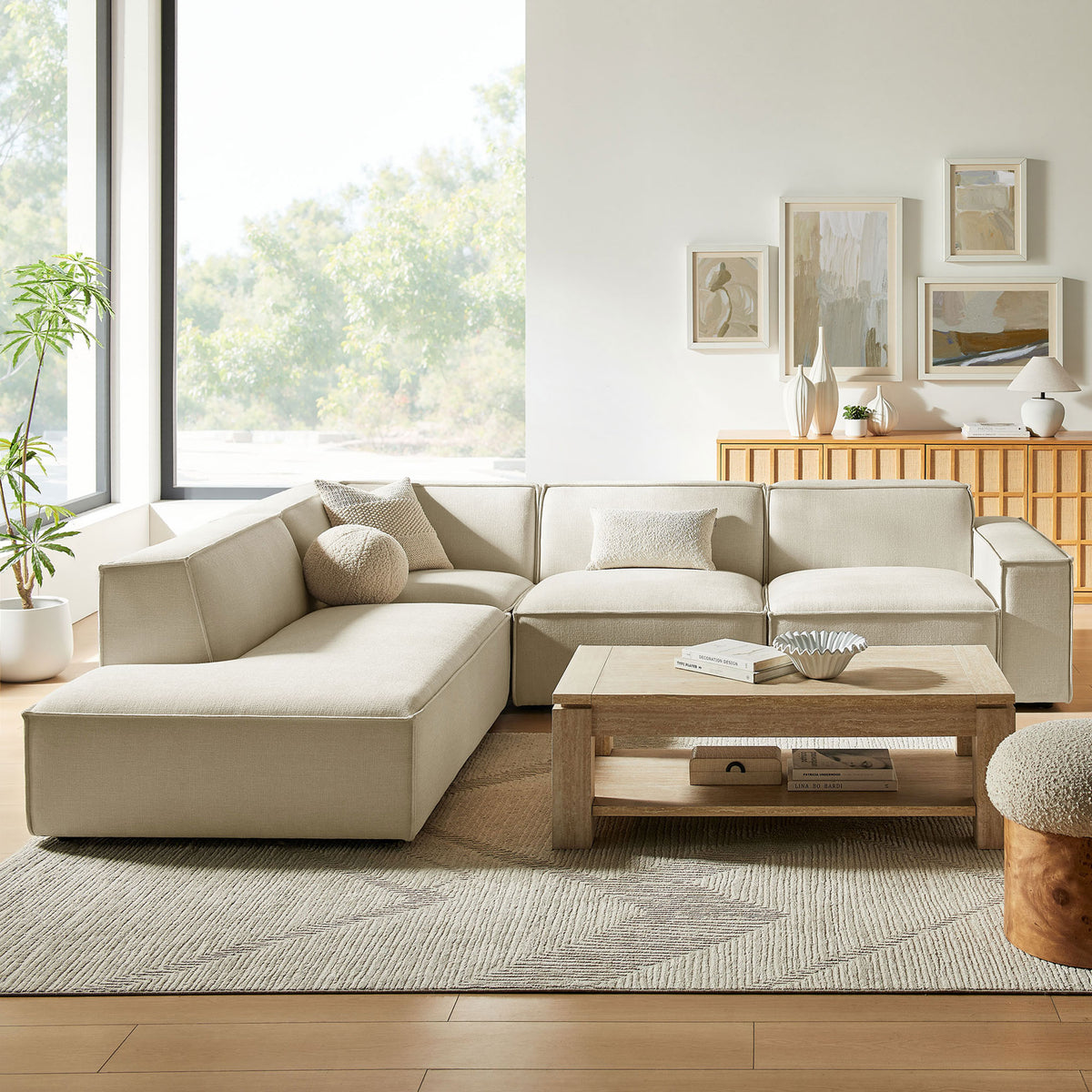 Restore ecru modular sectional anchored in a modern living room with light wood coffee table and decor || EEI-7431-ECR || front_angle_room