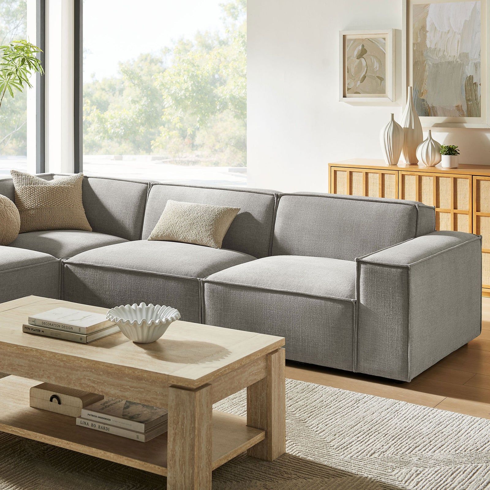 Pewter modular sofa with left chaise styled with textured throw pillows and a modern wood coffee table || EEI-7431-PEW || front_angle_room