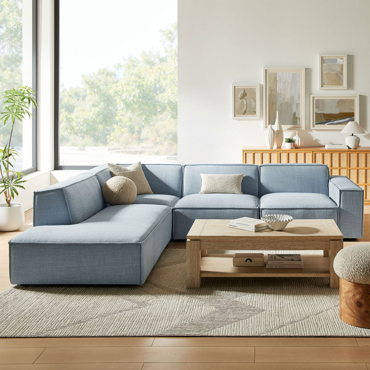 Sky blue modular sectional styled in a bright living room with neutral rug and wood coffee table || EEI-7431-SKY || front_angle_room
