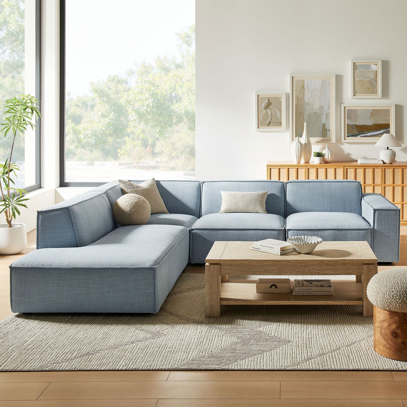 Sky blue modular sectional styled in a bright living room with neutral rug and wood coffee table || EEI-7431-SKY || front_angle_room