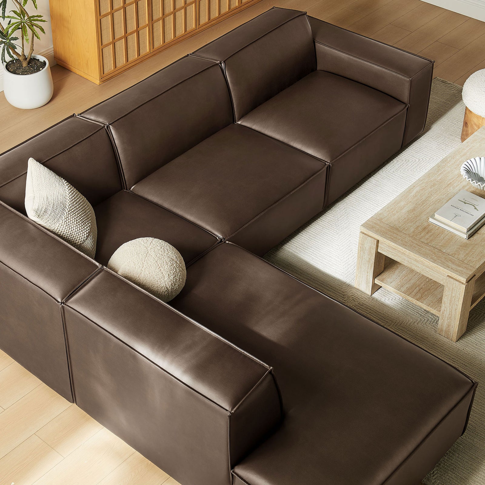 Modular espresso vegan leather sectional with spacious chaise and deep seats, integrating seamlessly into a warm modern living area || EEI-7432-ESP || top_angle_room