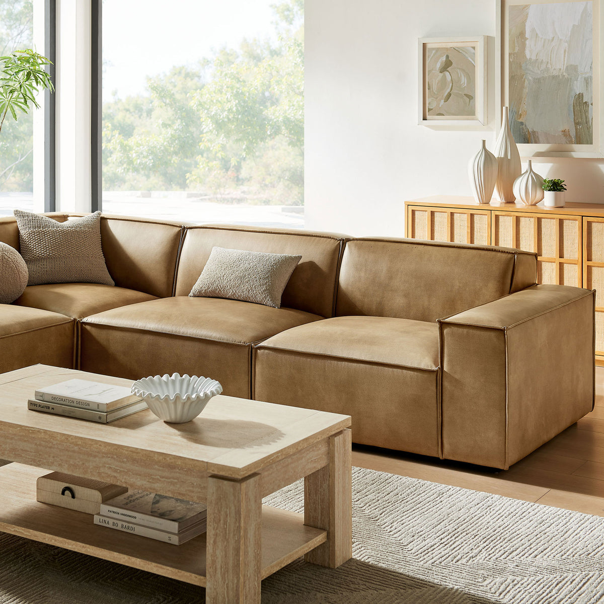 Plush seat cushions and tailored vegan leather upholstery layered with textured accent pillows || EEI-7432-TST || detail_room