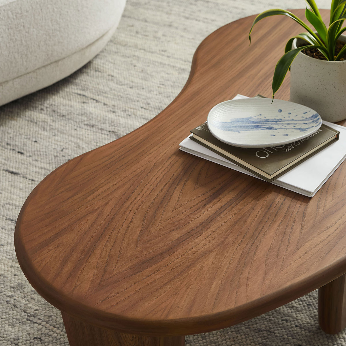 Curved walnut wood grain tabletop styled with decor in a bright living room || EEI-7437-WAL || detail_room