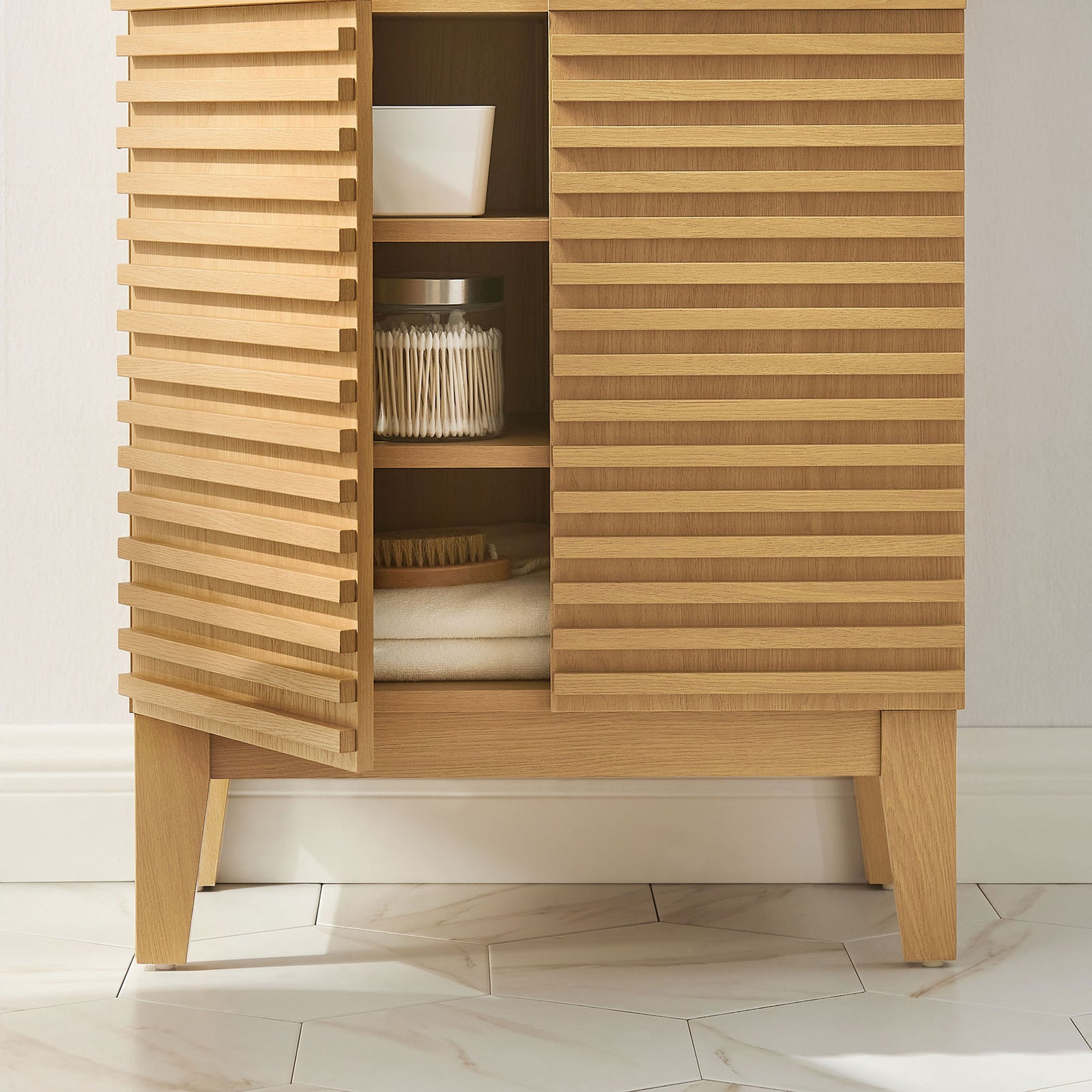 Slatted doors reveal shelving for bath essentials, complemented by sturdy tapered legs. || EEI-7439-OAK || detail_room