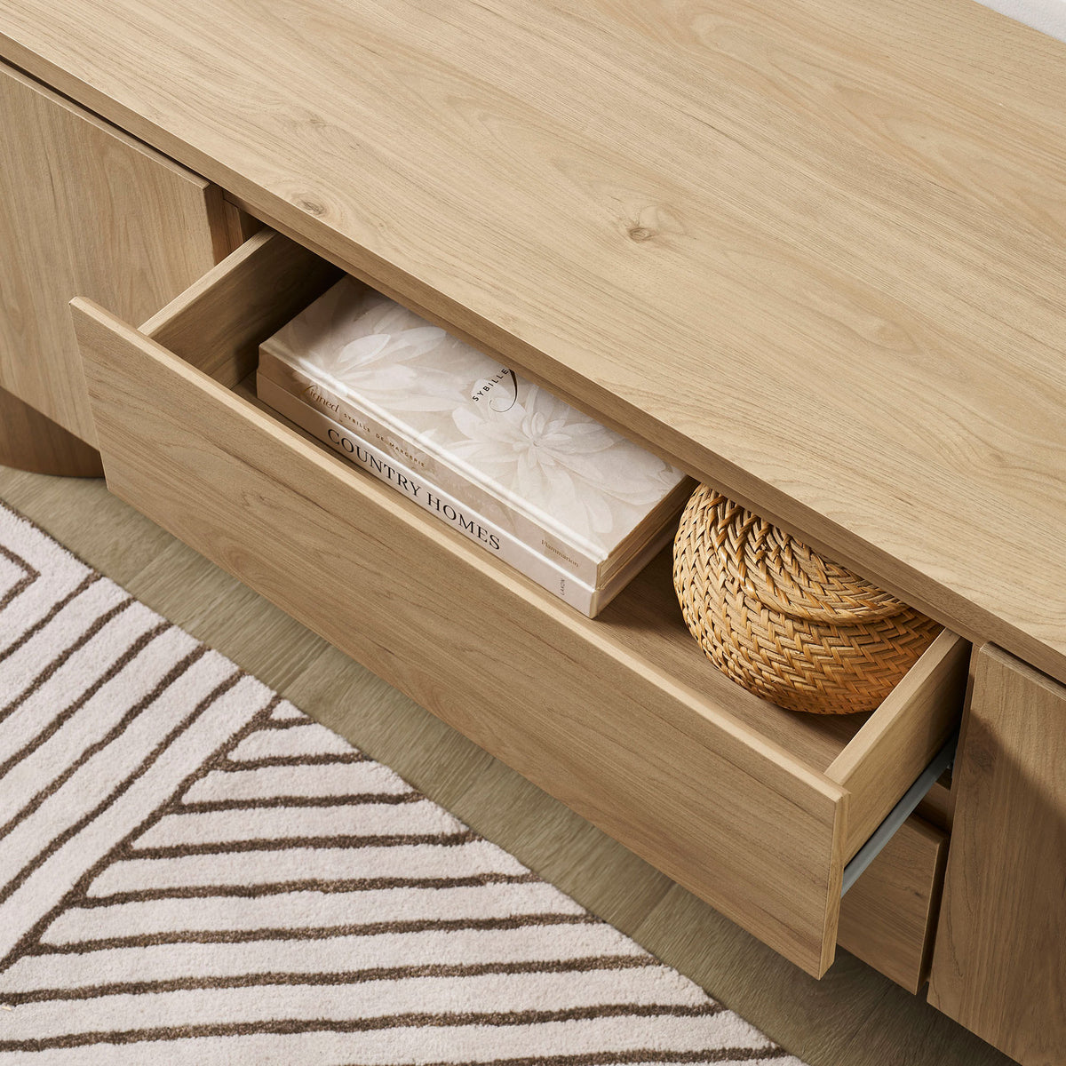 Open drawer of the light oak TV cabinet styled with decor in a cozy modern living room || EEI-7440-LOA || storage_open_room