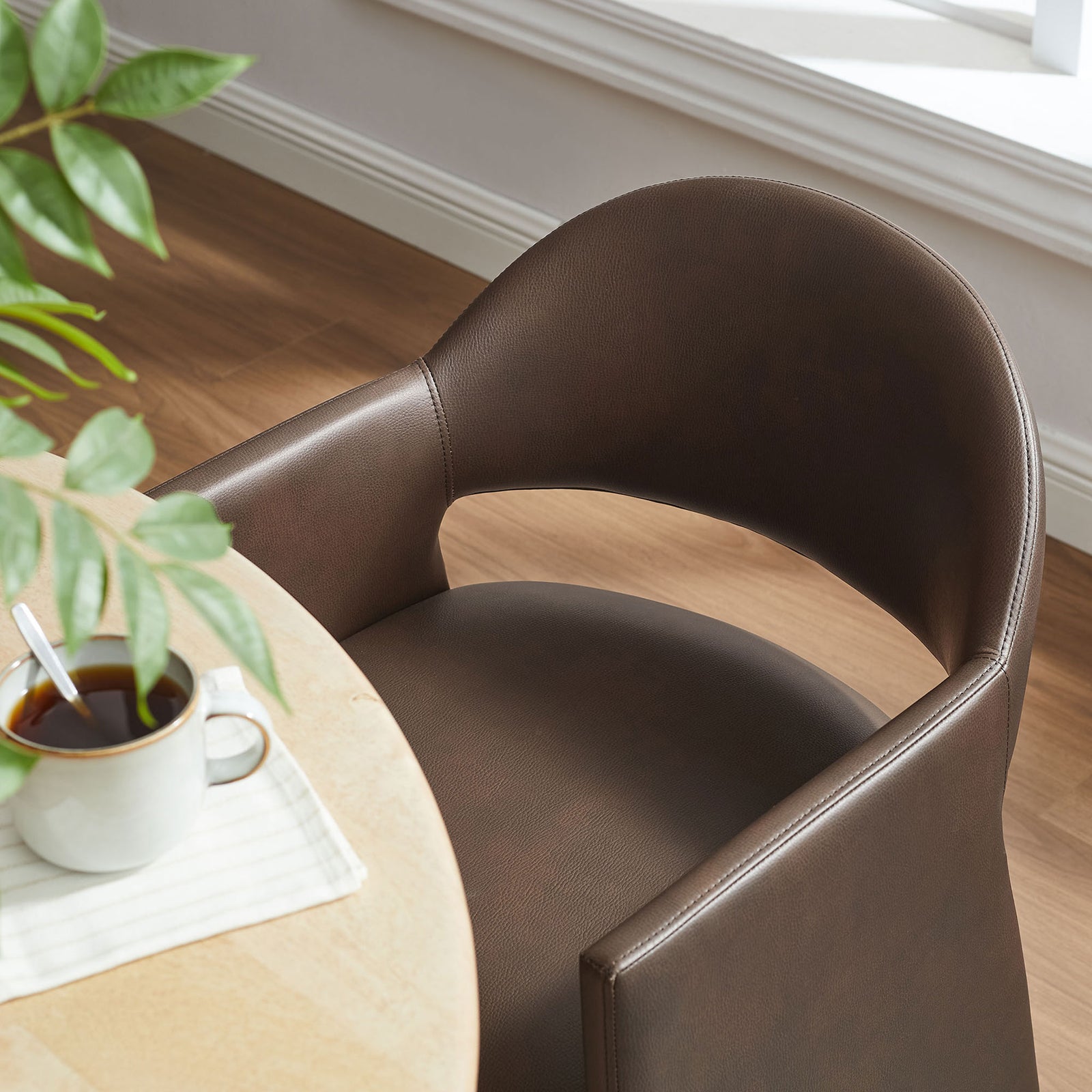Espresso dining armchair pulled to a light wood table, showing cozy barrel back in a bright room || EEI-7442-ESP || detail_room