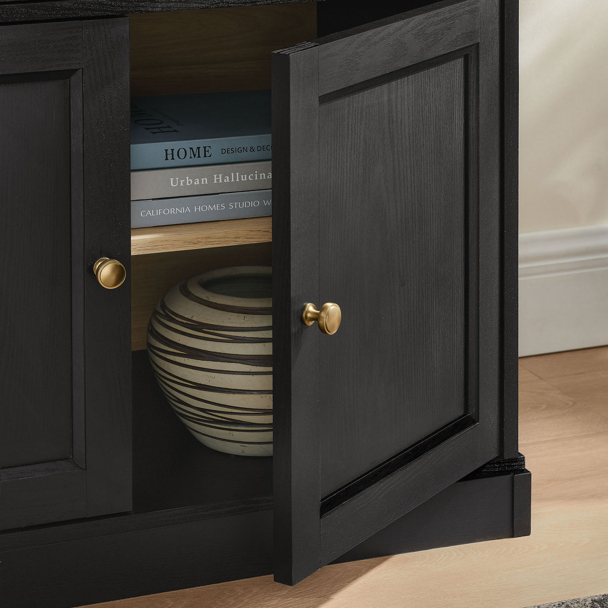 Lower cabinet door open to reveal shelf storage styled with decor in a contemporary living room || EEI-7449-BLK-OAK || storage_open_room