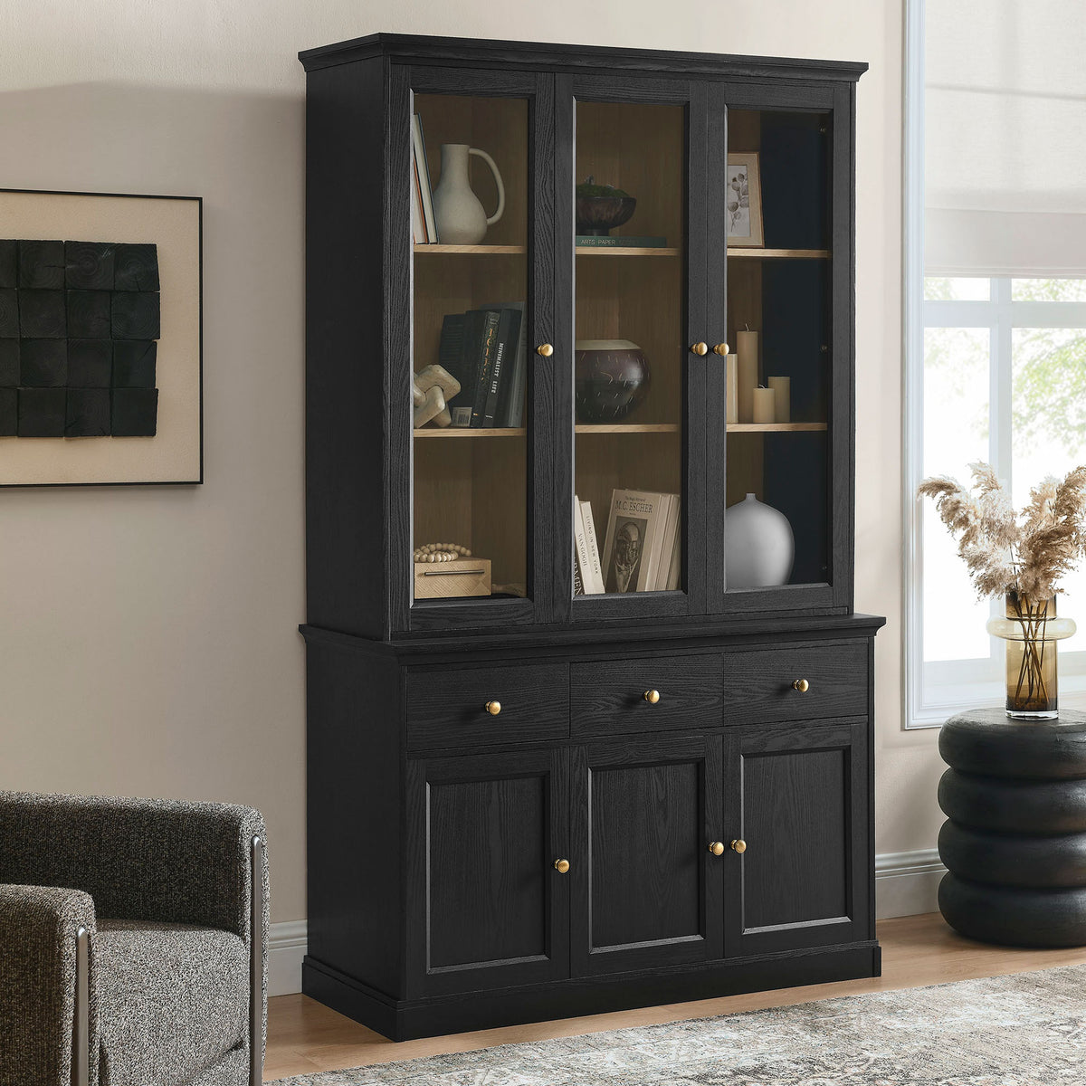 Black oak display cabinet styled in a bright living room with glass doors showcasing curated pieces || EEI-7449-BLK-OAK || front_angle_room