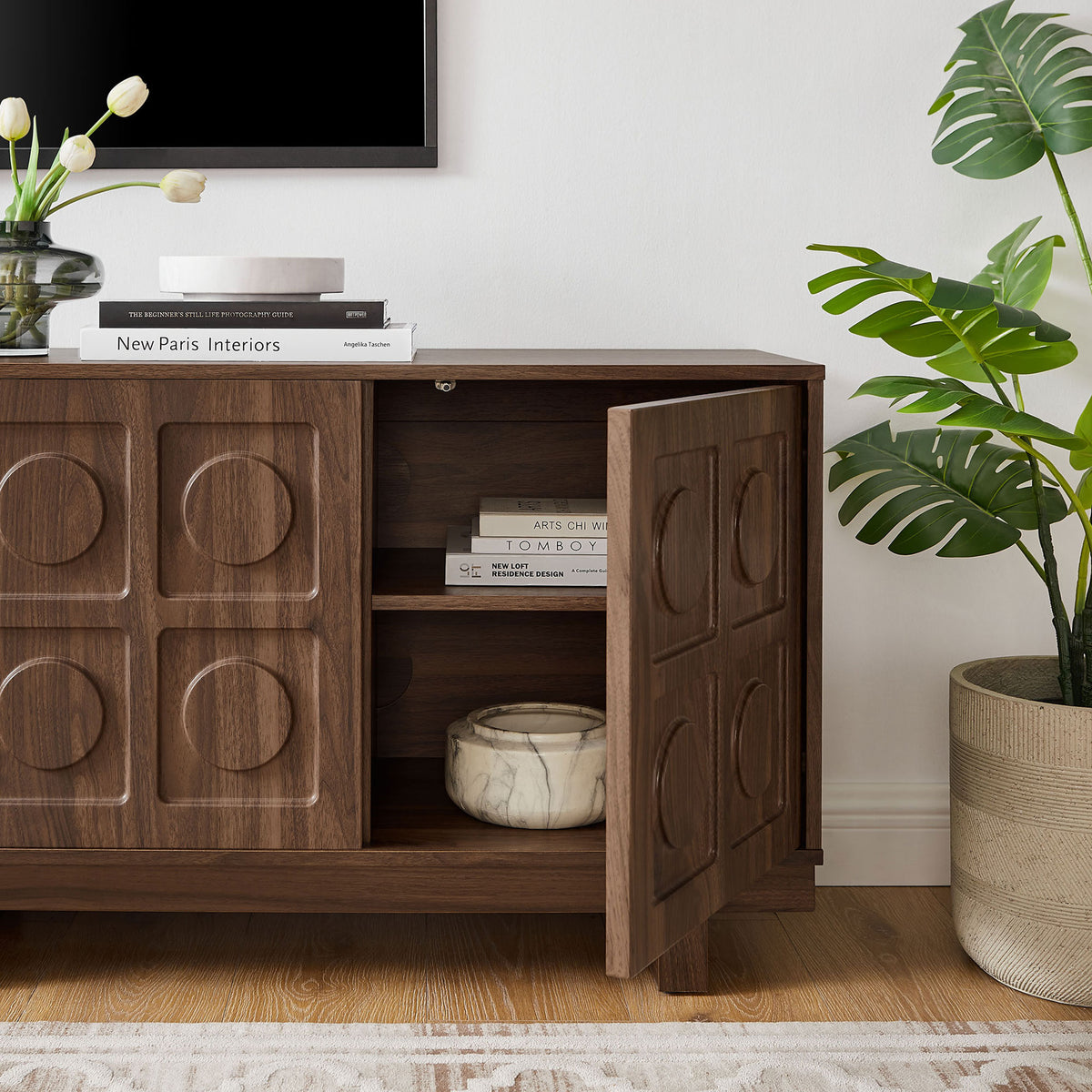 Walnut Knox TV stand in a light living room with one door open to show books and decor inside || EEI-7450-WAL || storage_open_room