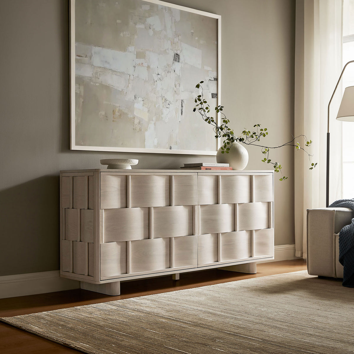White-wash woven-front buffet cabinet styled in a modern living room with artwork and decor || EEI-7452-WWA || front_angle_room