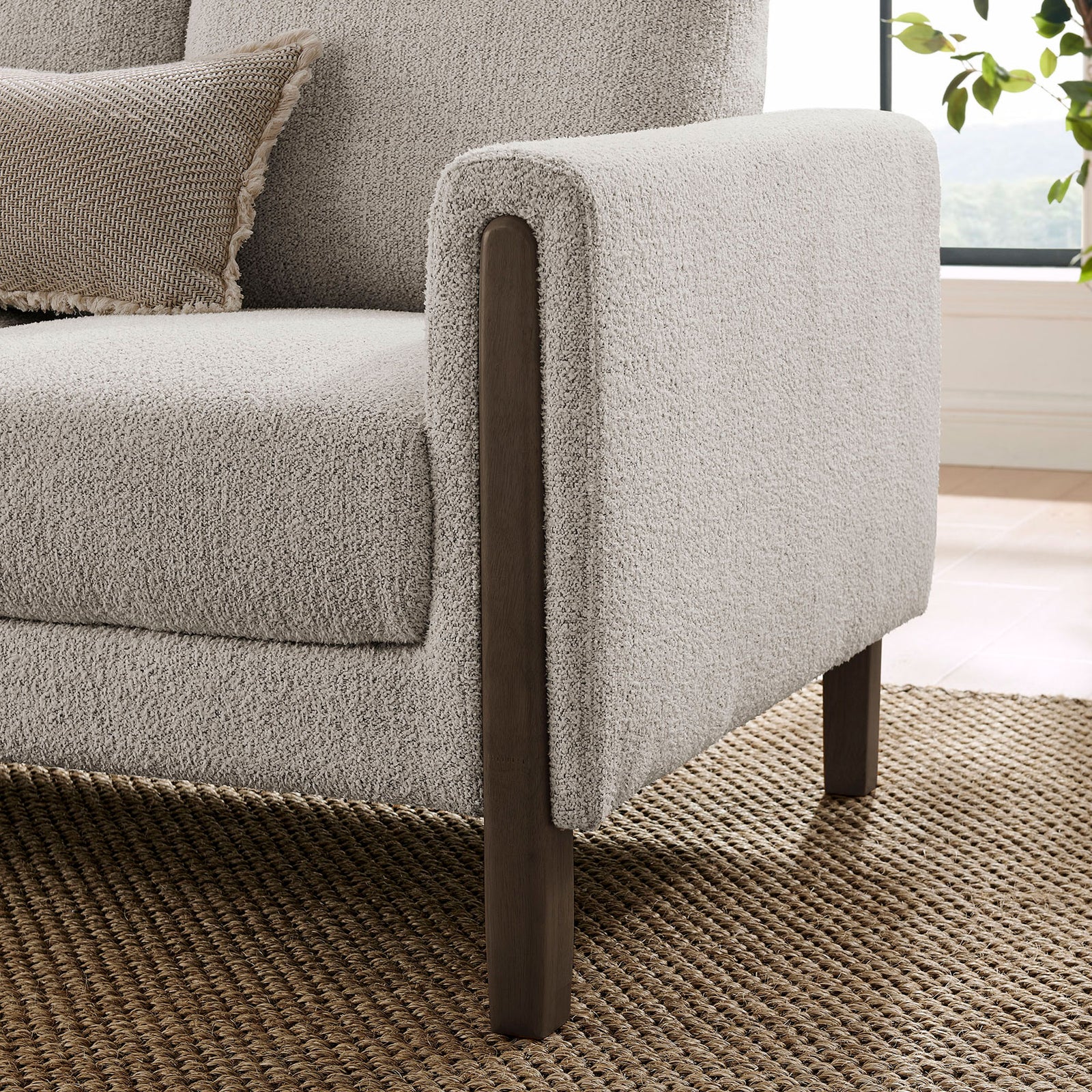 Sofa arm wrapped in boucle fabric with an espresso wood leg set on a natural woven rug || EEI-7461-PCH-ESP || leg_room