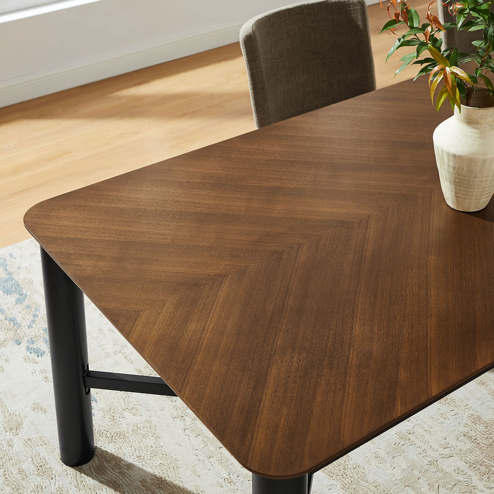 Walnut dining table styled with vase and greenery on a light rug in modern room || EEI-7463-WAL || detail_room