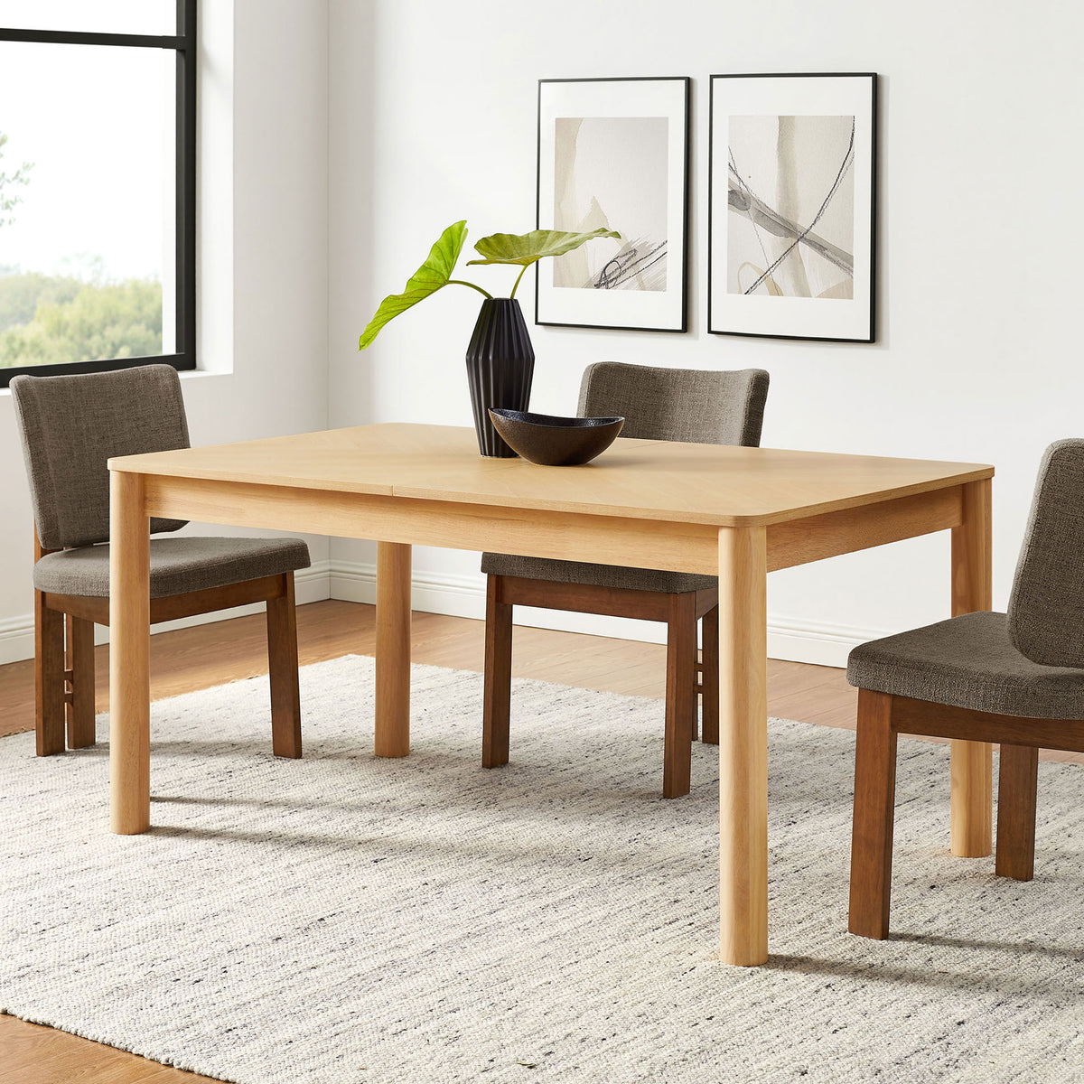 Alba oak dining table anchors a bright dining room, pairing easily with upholstered chairs and decor. || EEI-7464-OAK || front_angle_room