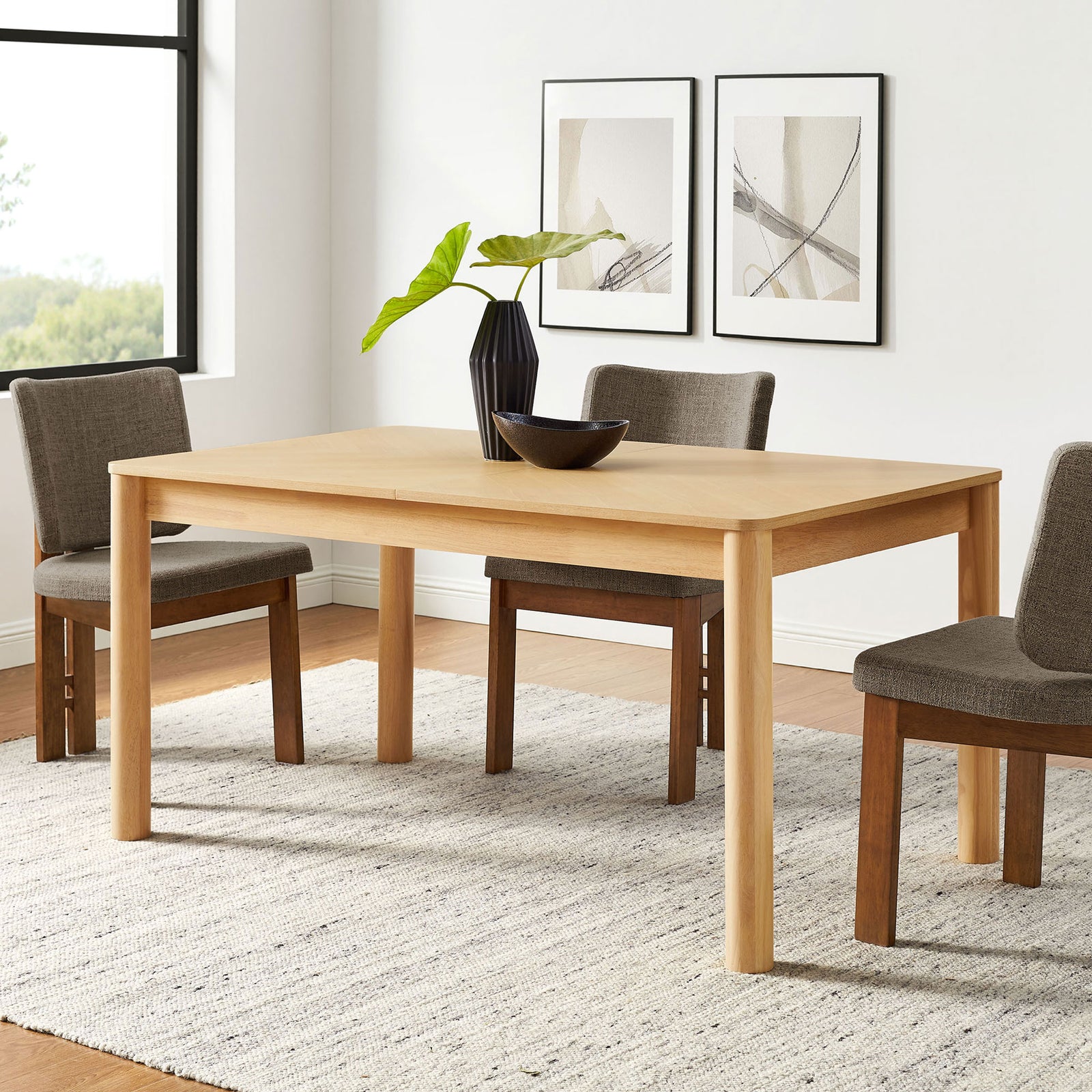 Alba oak dining table anchors a bright dining room, pairing easily with upholstered chairs and decor. || EEI-7464-OAK || front_angle_room