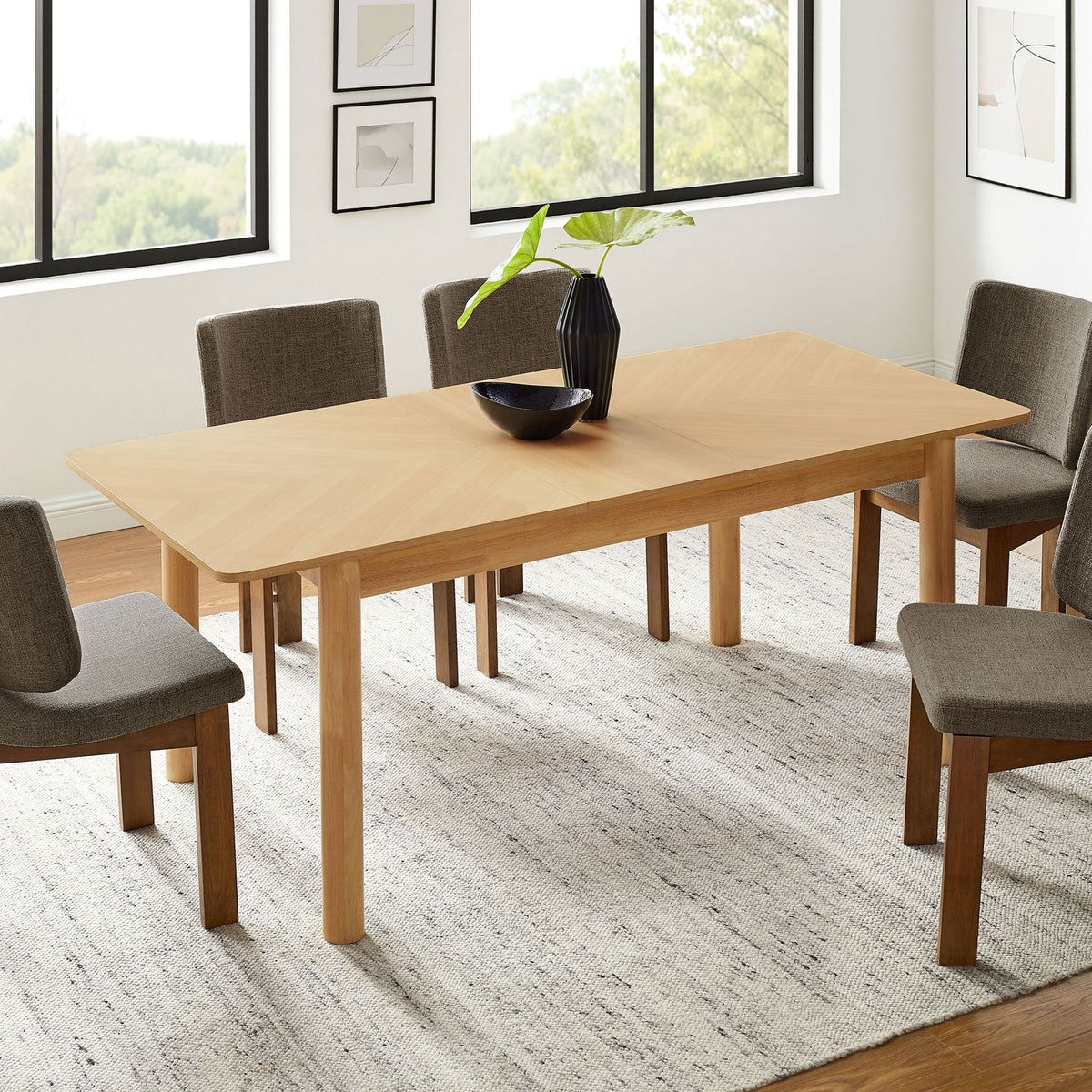 Alba extendable dining table opened to host a larger gathering with seating for six in a modern space. || EEI-7464-OAK || front_angle_converted_room