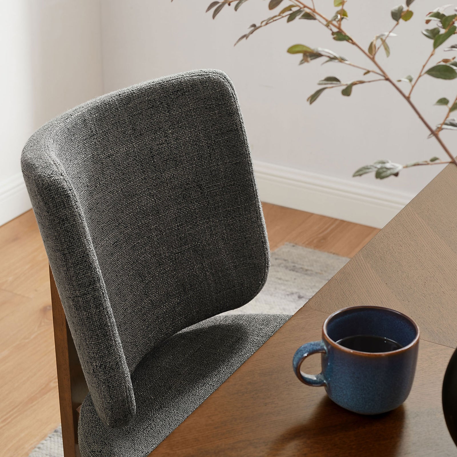 Charcoal chair back adds soft comfort to a warm wood dining table setting with modern decor. || EEI-7465-CHA || detail_room