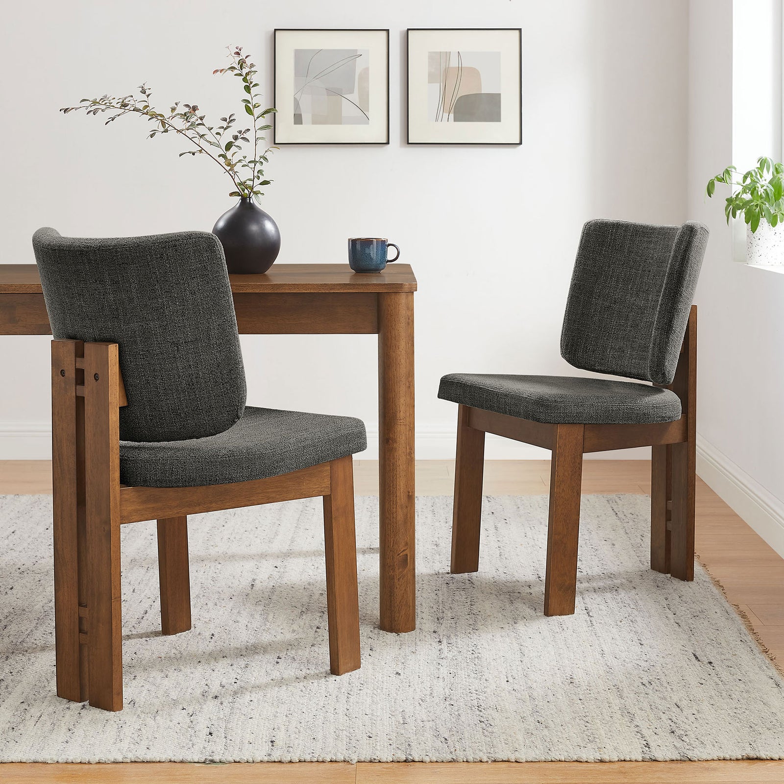 Pair of charcoal dining chairs frame a cozy table vignette on a light rug in a bright room. || EEI-7465-CHA || front_angle_multi_room