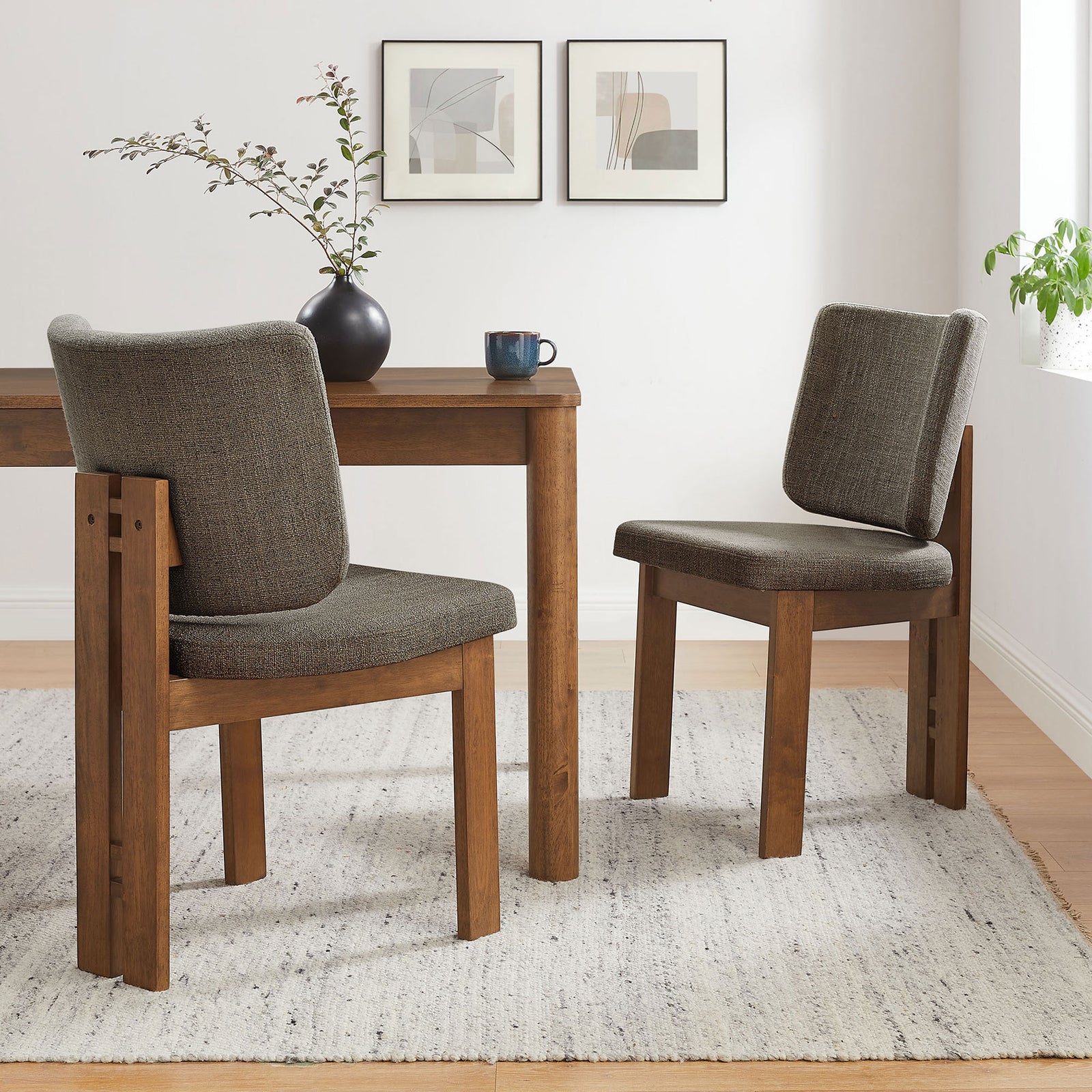 Pair of taupe upholstered dining chairs around a wooden table on a textured rug in a bright dining nook || EEI-7465-TAU || front_angle_multi_room