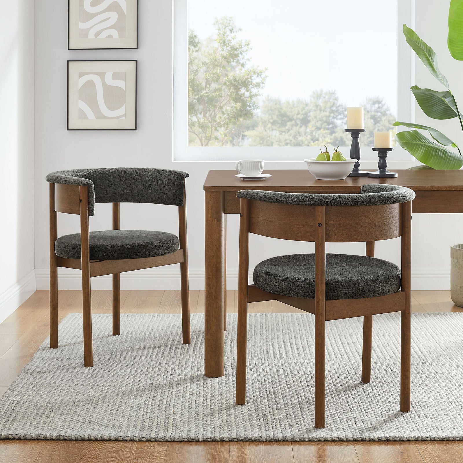 Pair of charcoal curved dining chairs around a wood table creating a cozy, modern dining space || EEI-7467-CHA || front_angle_multi_room