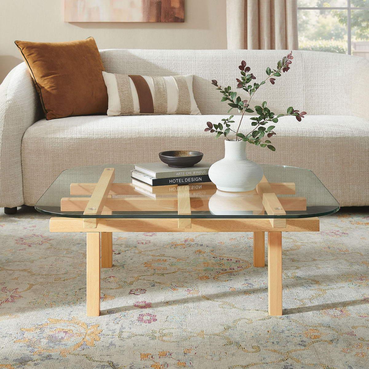 Modern coffee table pairs a clear glass top with an airy oak-finished lattice base for sculptural style. || EEI-7468-OAK || front_angle_room