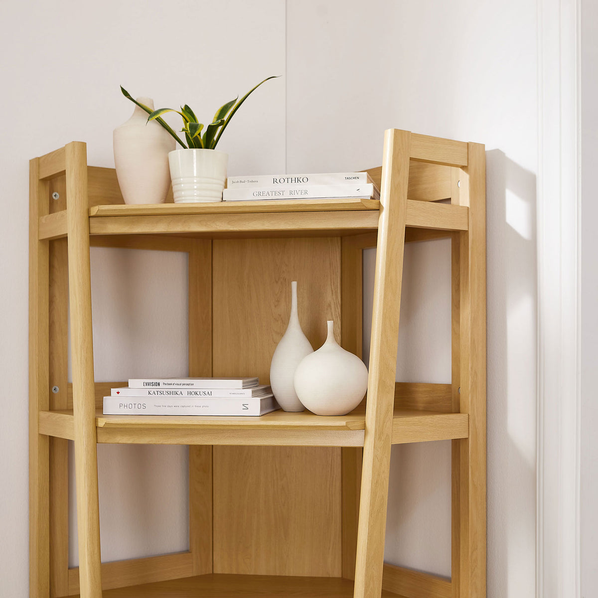 Styled oak corner shelving showcases airy frame and clean, open tiers for books and decor || EEI-7469-OAK || detail_room