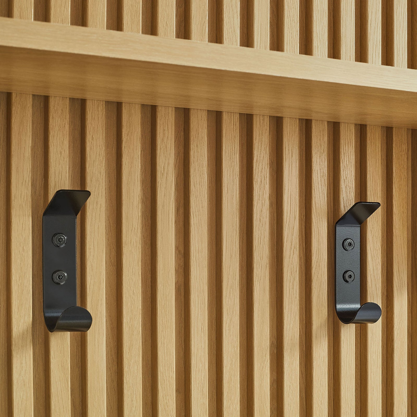 Matte black double hooks sit beneath the sturdy shelf on the fluted oak panel || EEI-7472-OAK || storage_studio