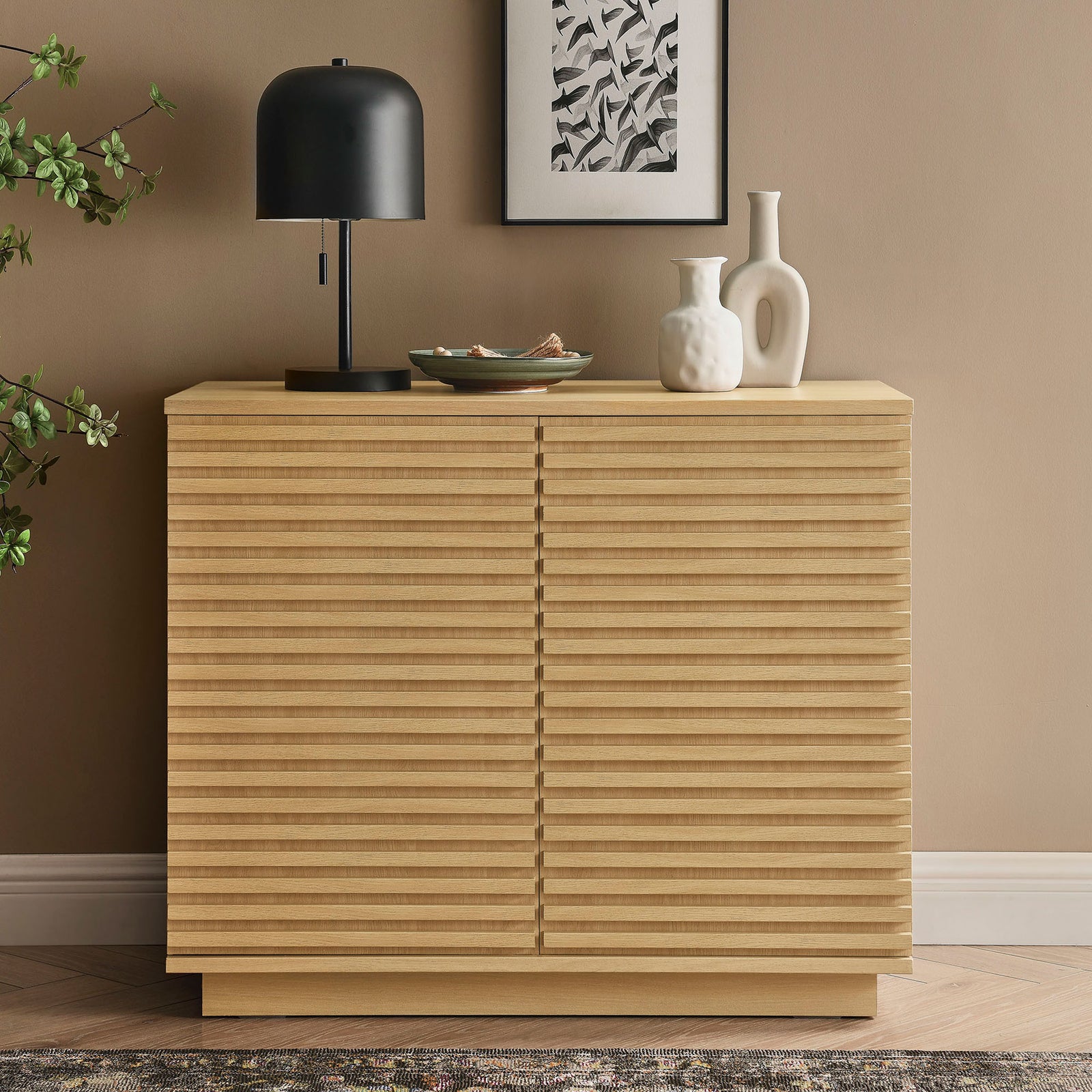 Oak fluted accent cabinet styled with decor in a warm modern living room setting || EEI-7476-OAK || front_angle_room