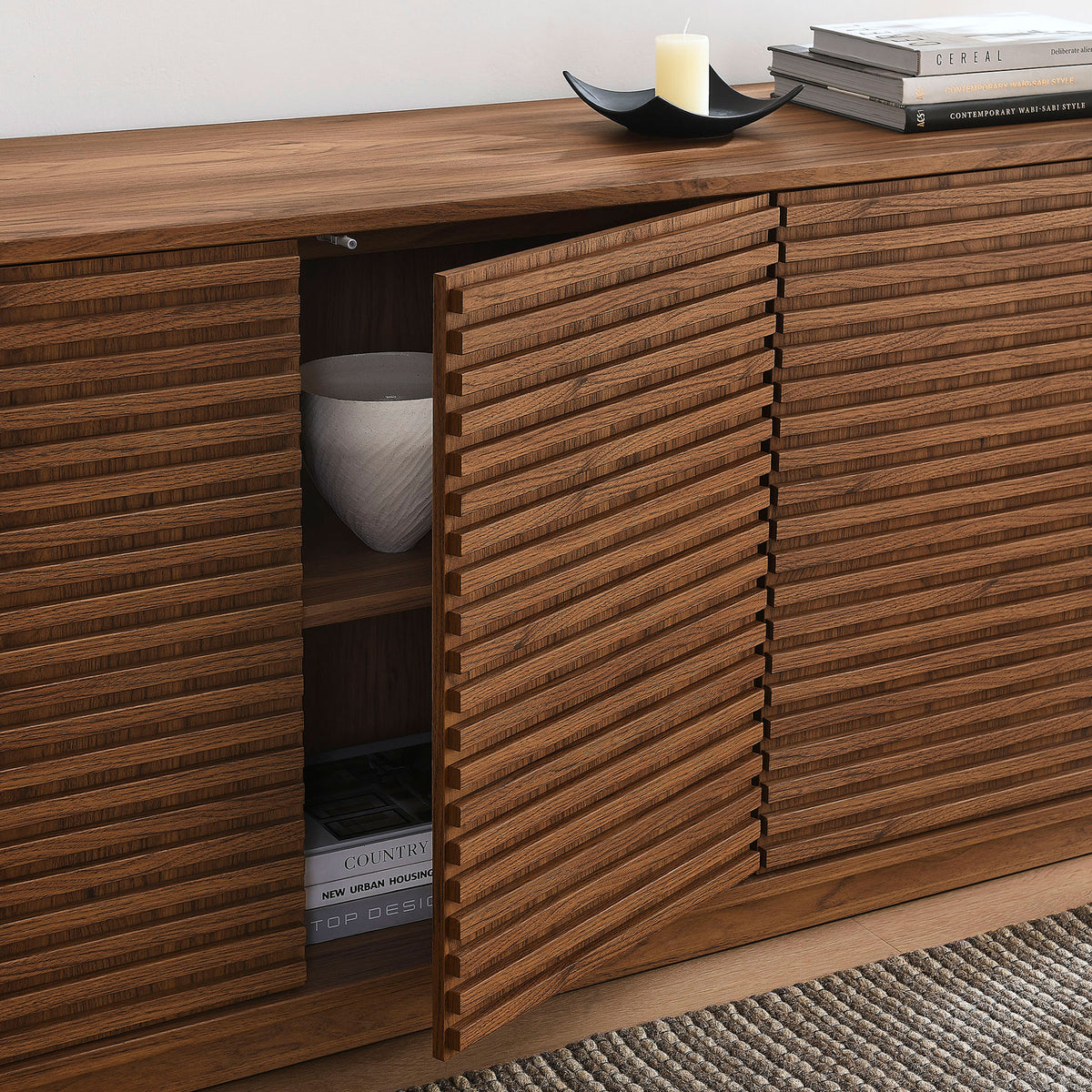 Walnut fluted sideboard styled in a modern living room with one door open to display decor and hidden storage || EEI-7477-WAL || front_angle_open_room