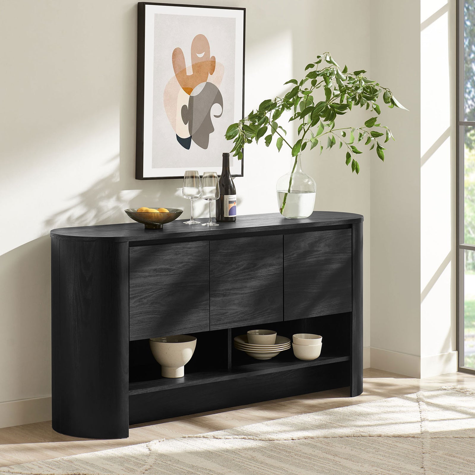 Black Duval sideboard styled in a bright living space with art, greenery, and everyday dining essentials || EEI-7478-BLK || front_angle_room