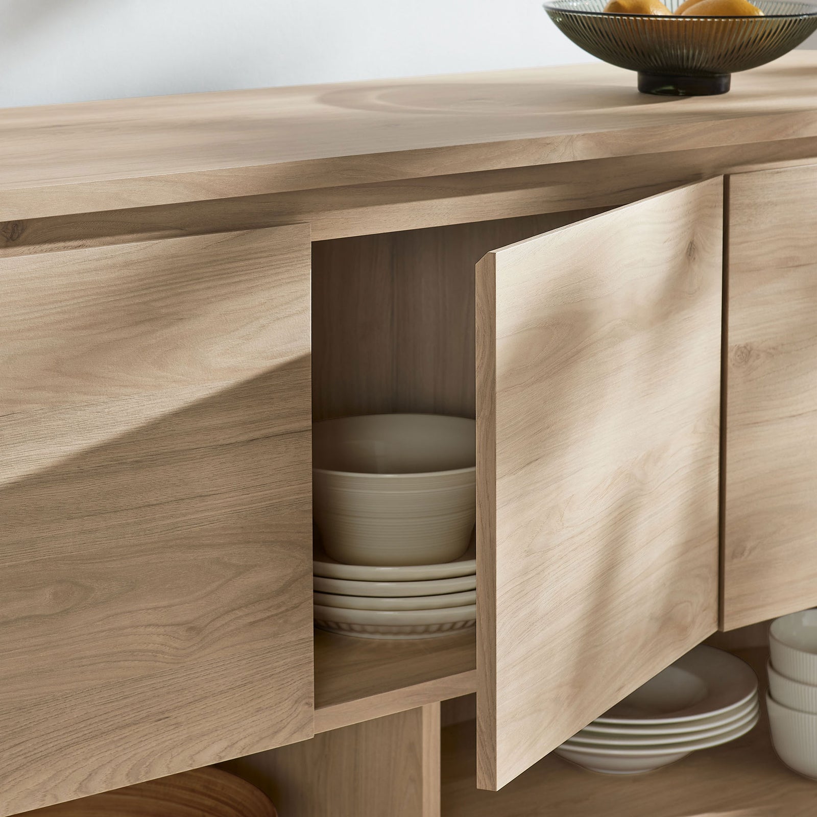 Interior cabinet shelving neatly organizes stacked dishes and bowls inside the light oak sideboard || EEI-7478-LOA || storage_open_room