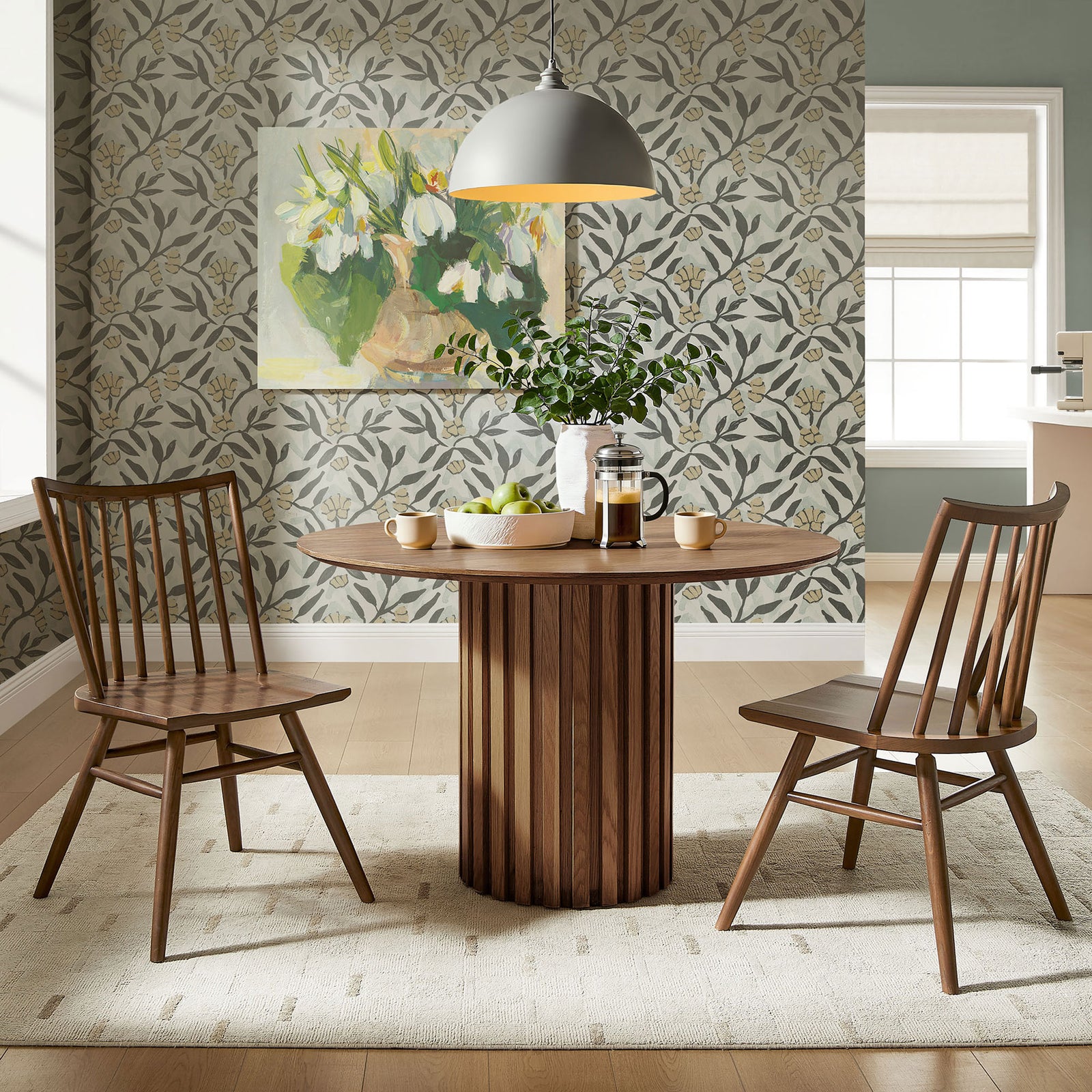 Pair of walnut spindle back dining chairs arranged around a round wood table in a bright dining room || EEI-7482-WAL || front_angle_multi_room