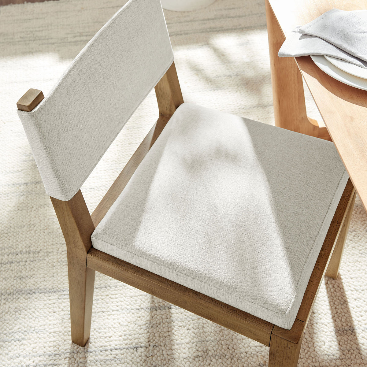 Ivory cushioned dining chair bringing soft texture and comfort to a bright dining space || EEI-7485-HEI || detail_room