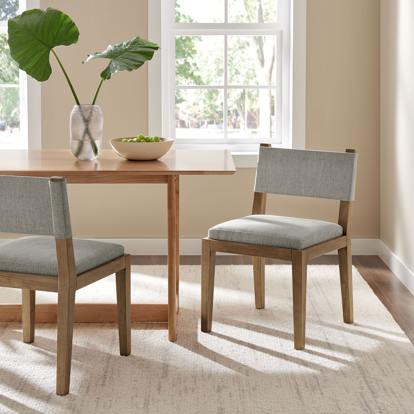 Calder wheat fabric dining chairs around a modern wood table in a bright dining room || EEI-7485-HEW || front_angle_room