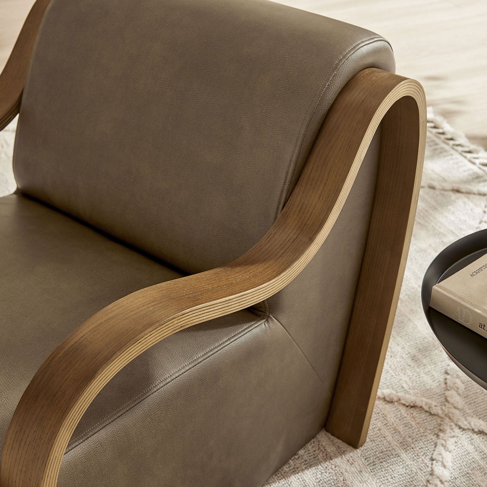 Textured vegan leather and curved bentwood arm enhance the chair's soft, inviting feel in the room. || EEI-7491-MUS || detail_room