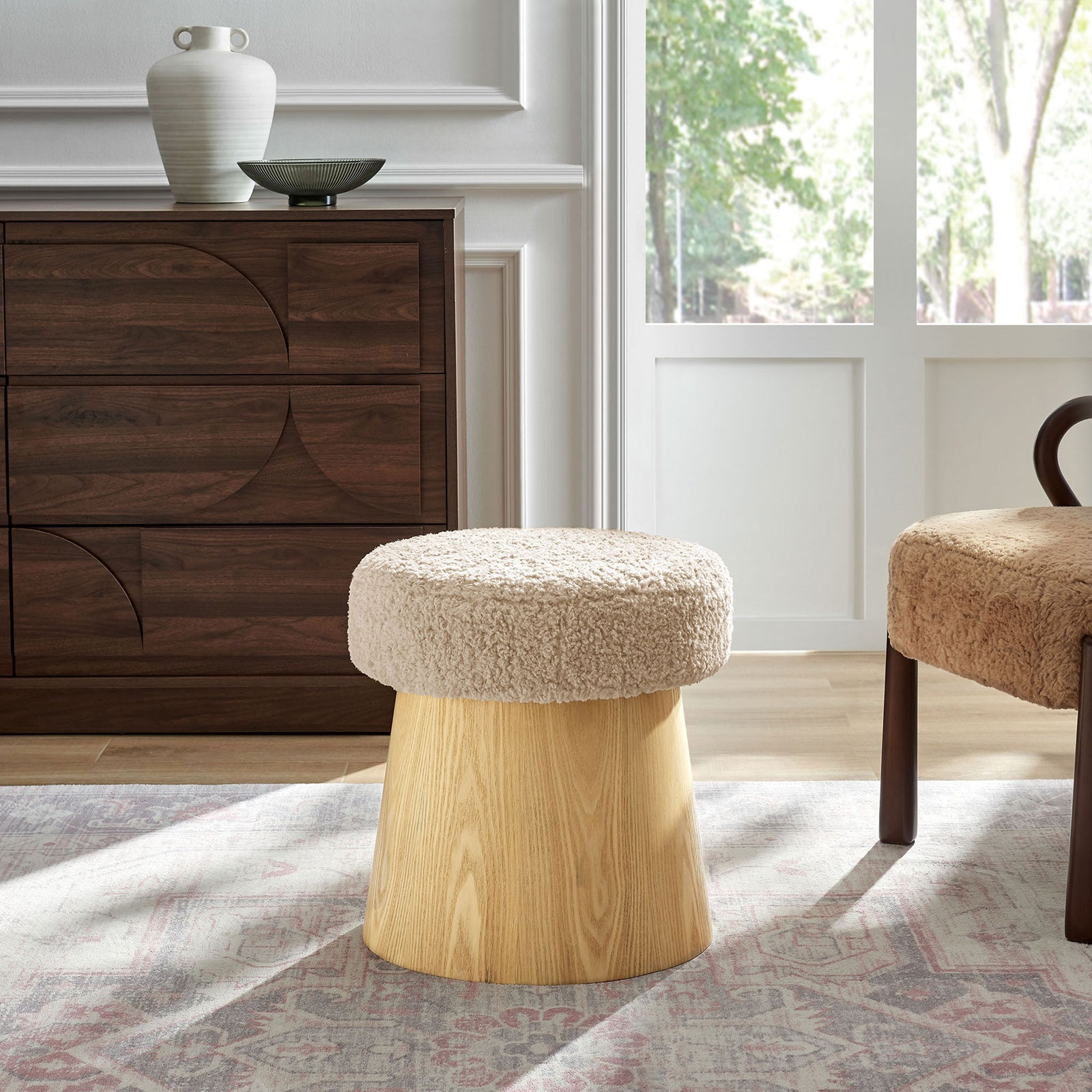 Ketra round faux shearling ottoman styled in a modern living room with warm wood furniture and rug || EEI-7493-OAT-OAK || front_angle_room