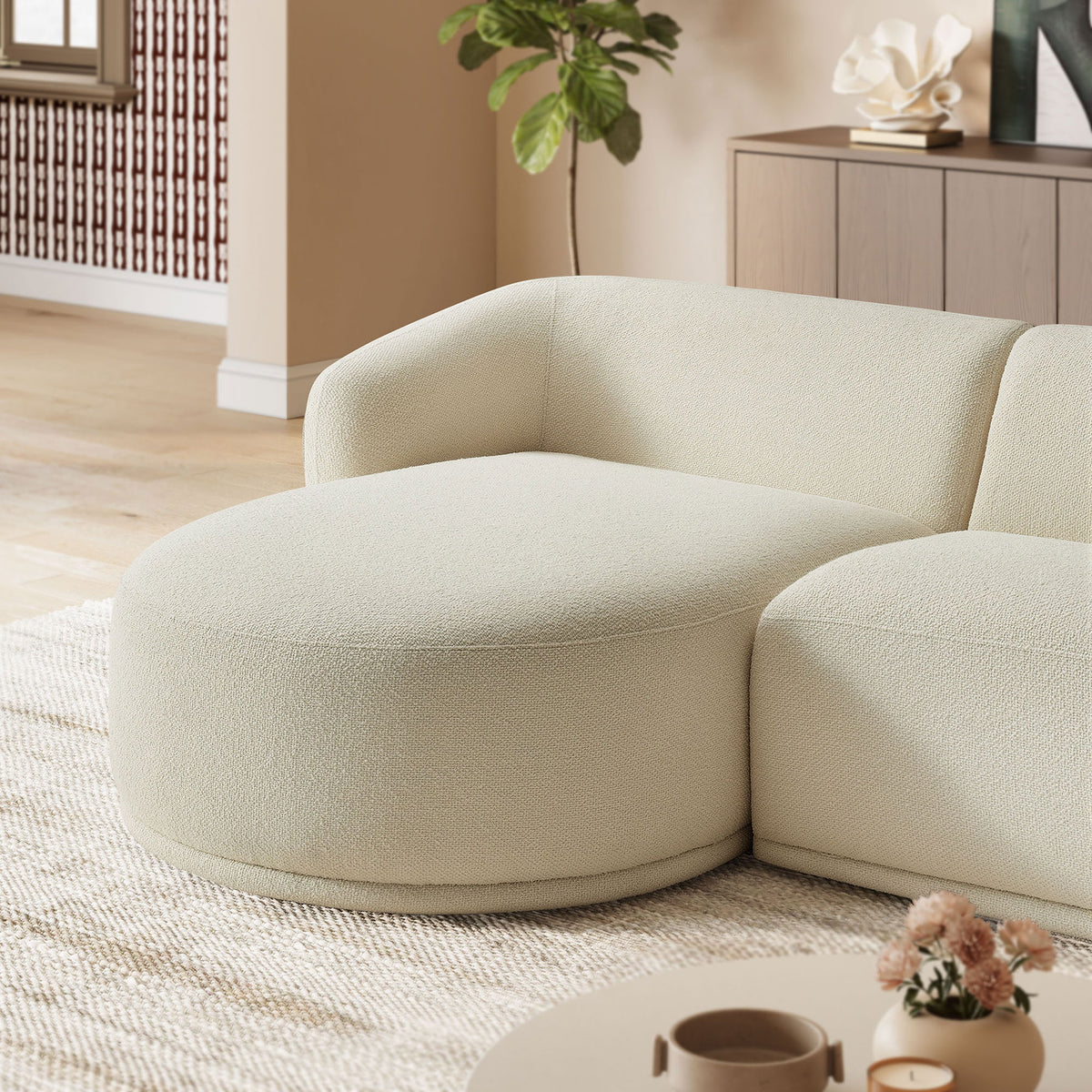 Cream boucle chaise corner of the Monica sectional layered with soft accents in a cozy living room. || EEI-7502-CRE || detail_room