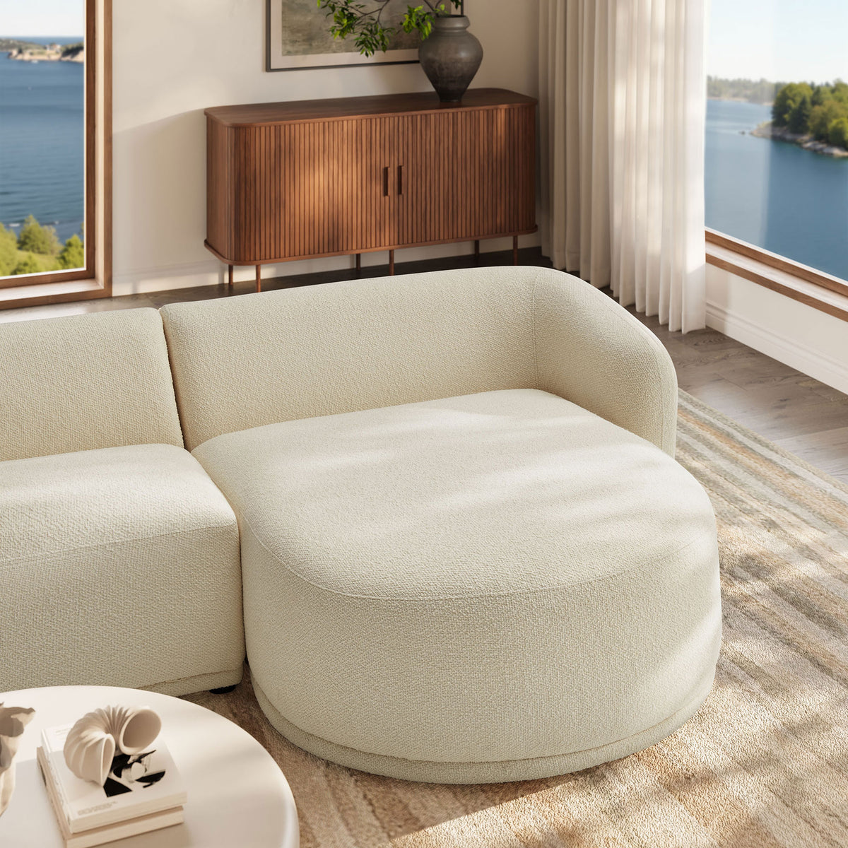 Cream chaise end of the Monica sectional pairs with a modern pedestal table in a sunlit room. || EEI-7503-CRE || detail_room