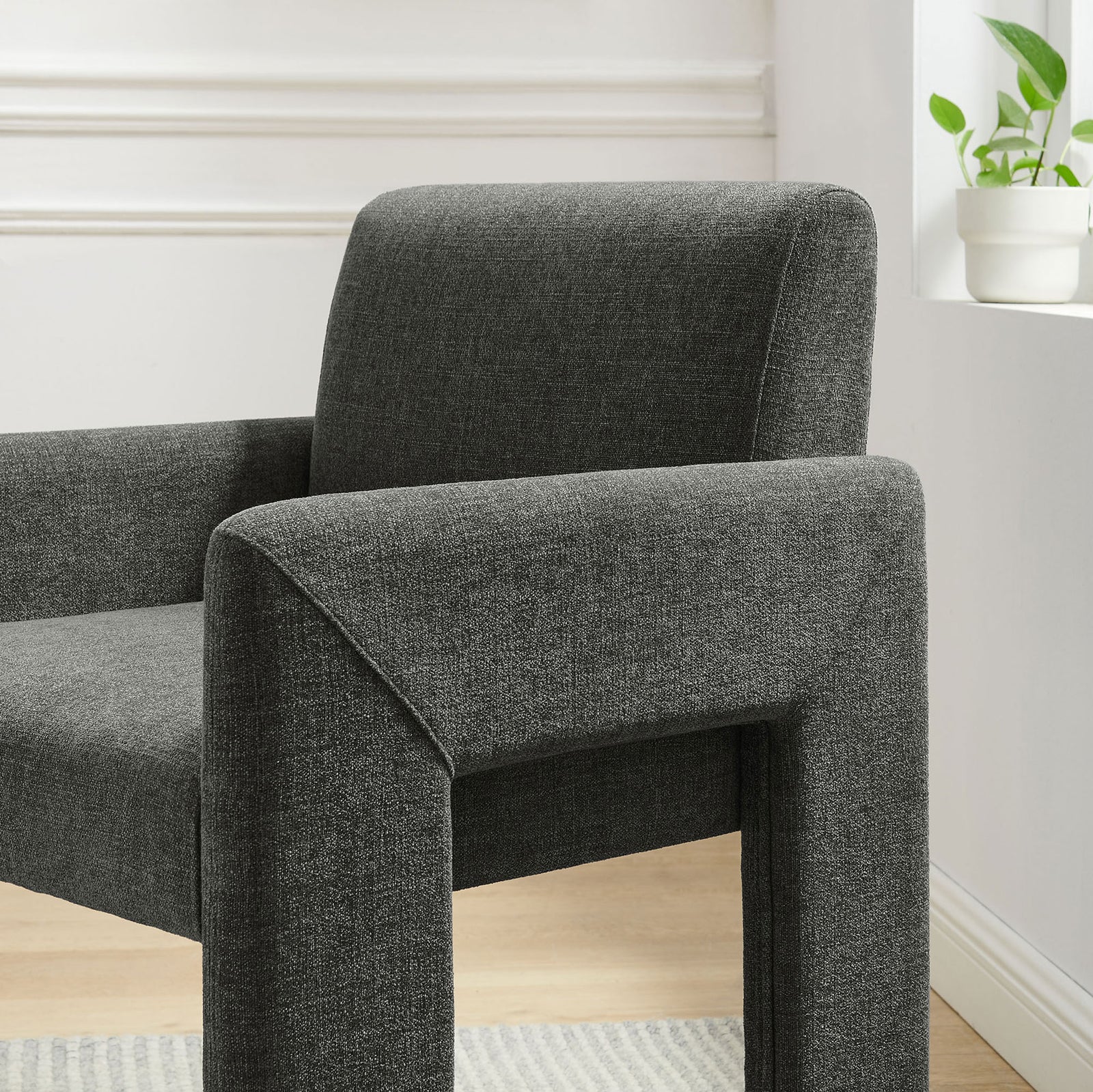 Charcoal dining chair styled by a bright window, showcasing soft fabric texture and plush back cushion. || EEI-7524-CHA || detail_room