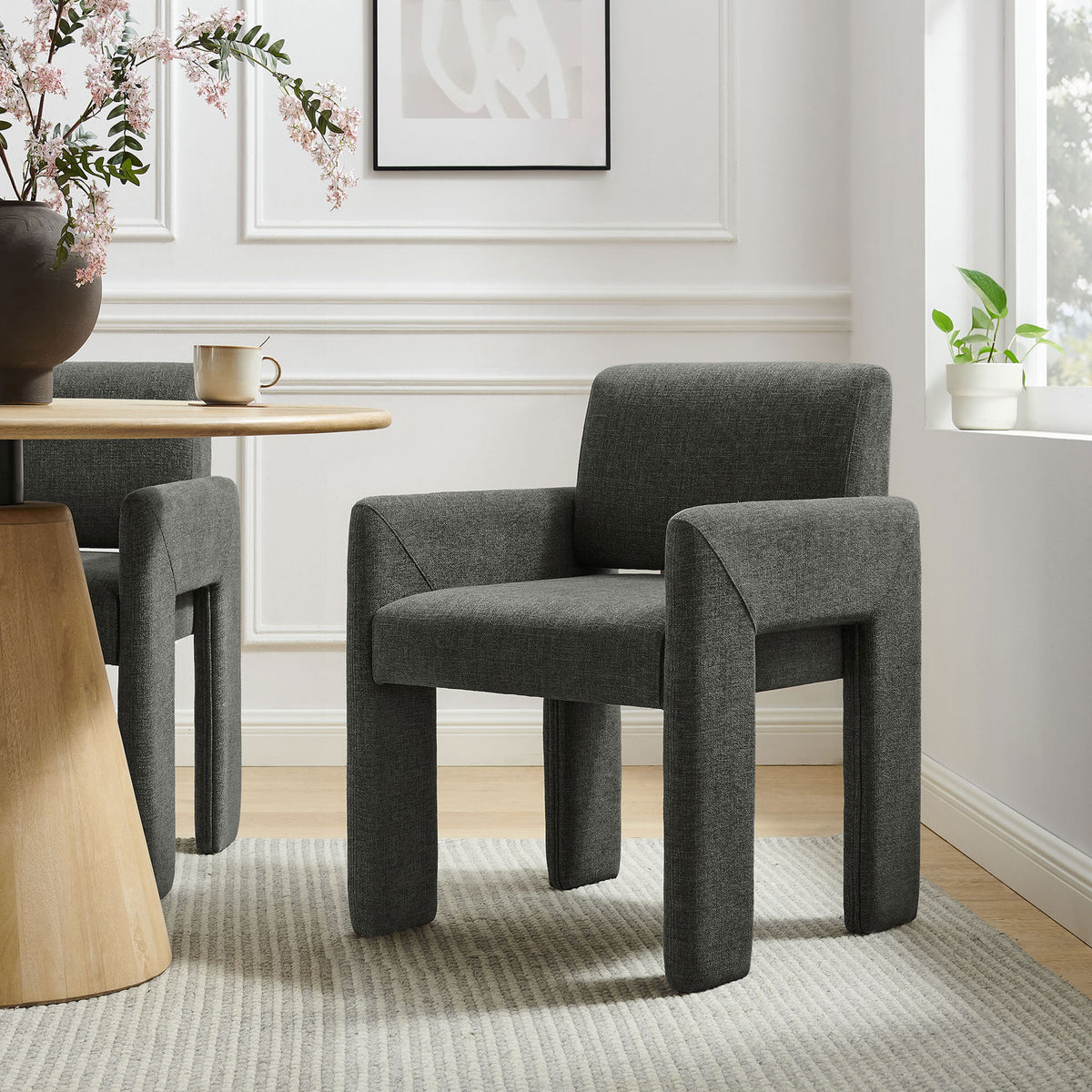 Modern charcoal upholstered dining chair paired with a wood table, adding sculptural style to the room. || EEI-7524-CHA || front_angle_room